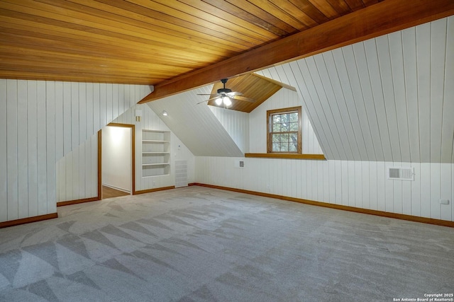 additional living space featuring built in shelves, wood ceiling, light carpet, and vaulted ceiling with beams