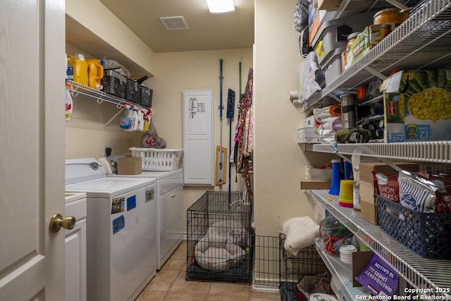 laundry area with washer and dryer and light tile patterned floors