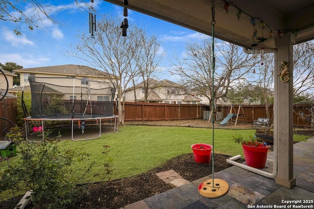 view of yard with a patio, a playground, and a trampoline