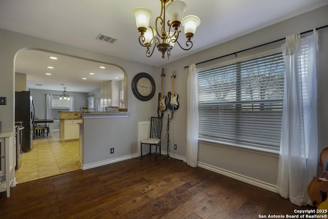 unfurnished dining area with light wood-type flooring and a notable chandelier