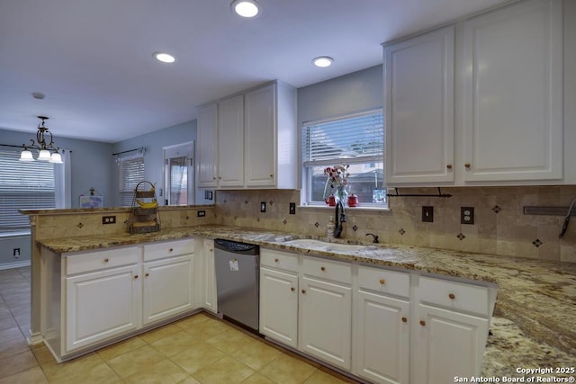 kitchen featuring stainless steel dishwasher, hanging light fixtures, decorative backsplash, white cabinetry, and sink