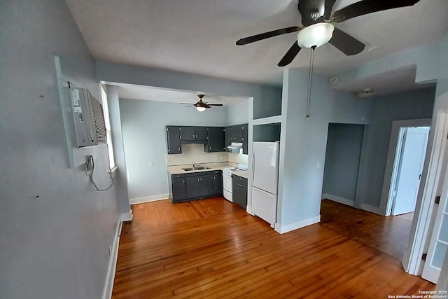 kitchen with hardwood / wood-style flooring, sink, white appliances, and ceiling fan