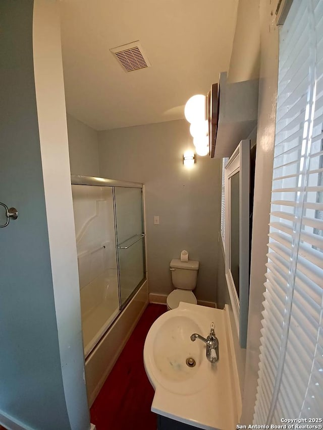 bathroom featuring an enclosed shower, vanity, and toilet