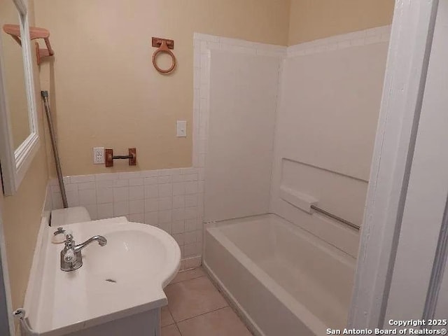 bathroom with tub / shower combination, vanity, tile walls, and tile patterned floors