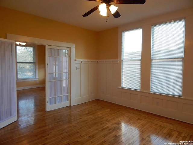 spare room featuring ceiling fan, hardwood / wood-style flooring, and french doors