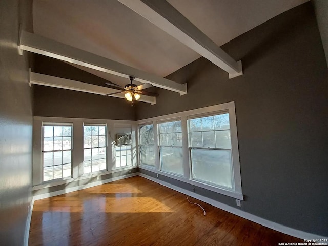 spare room with ceiling fan, vaulted ceiling with beams, and hardwood / wood-style floors