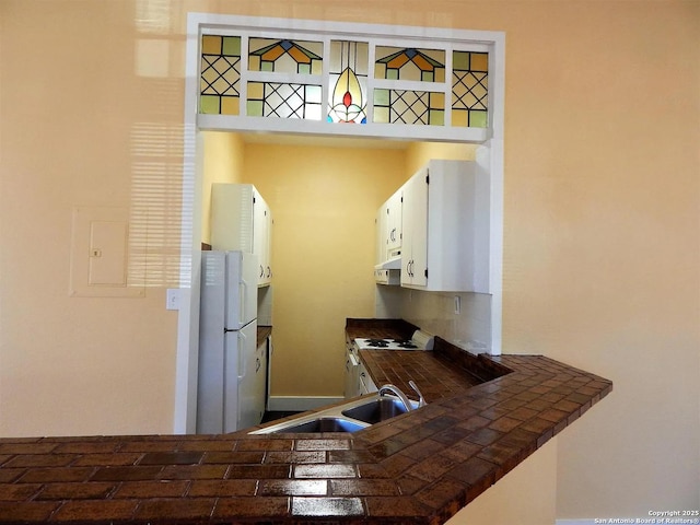 kitchen featuring tile counters, white cabinets, sink, and white appliances