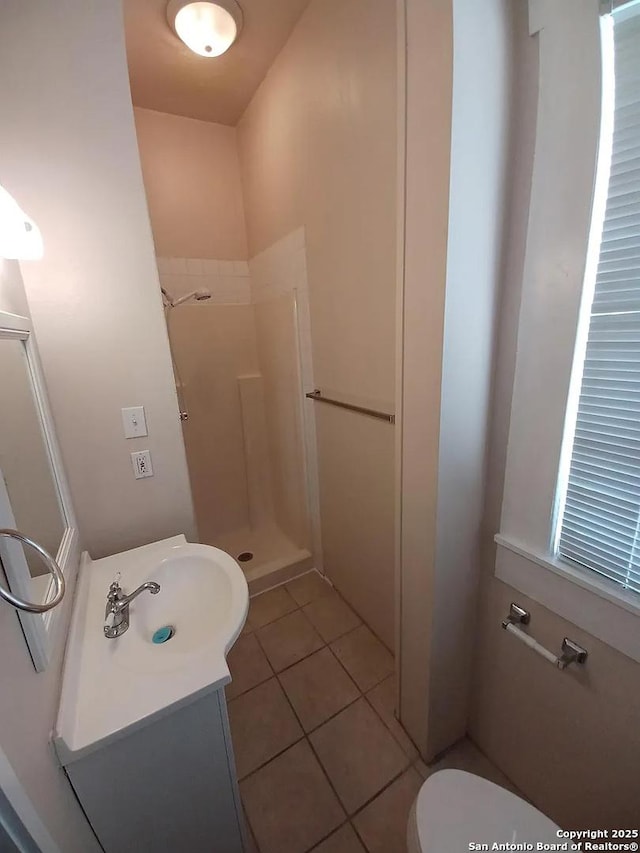 bathroom featuring a shower, toilet, vanity, and tile patterned flooring