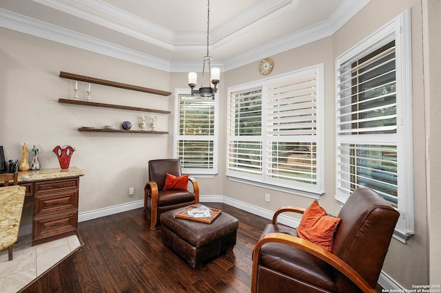 living area with a raised ceiling, wood-type flooring, crown molding, and a chandelier