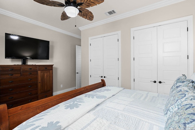 bedroom with two closets, ceiling fan, and crown molding