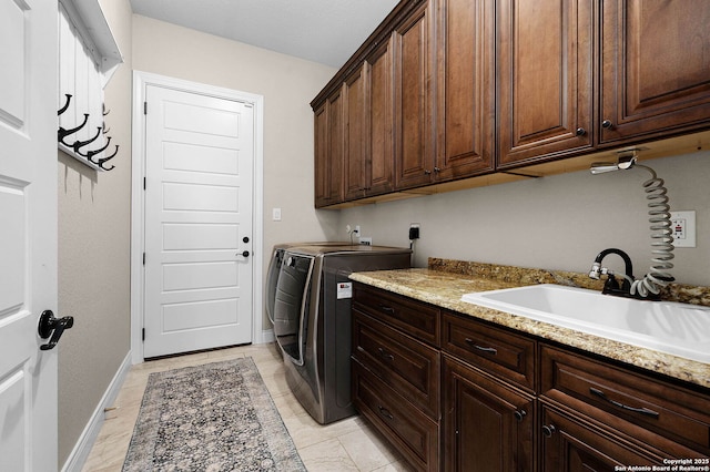 laundry room with washer and dryer, cabinets, light tile patterned floors, and sink