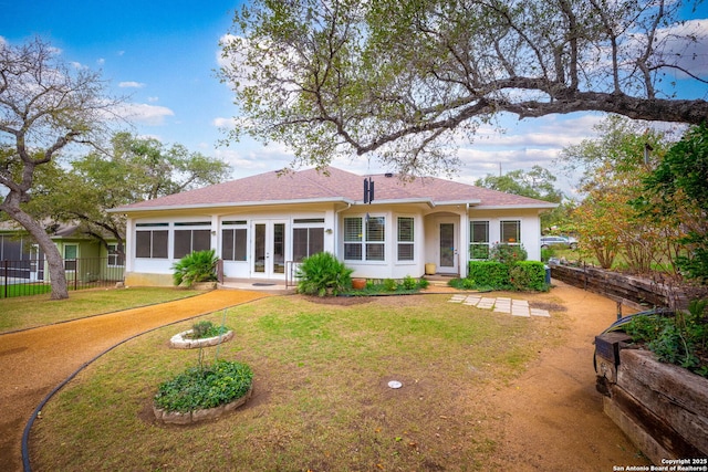 rear view of house featuring french doors and a yard