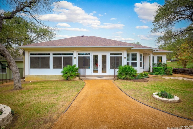 rear view of property featuring a lawn and french doors