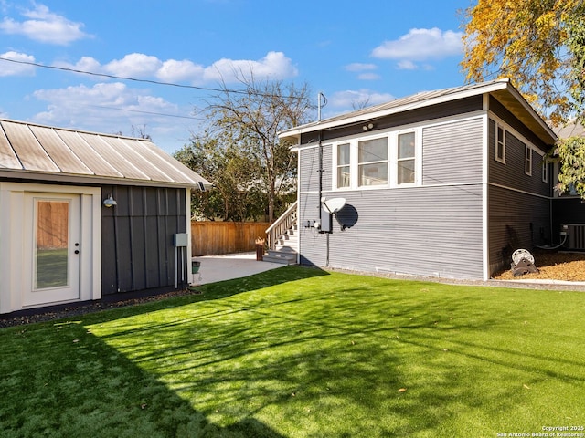 view of outdoor structure with a yard and central AC