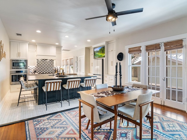 dining area with light hardwood / wood-style flooring, french doors, and ceiling fan