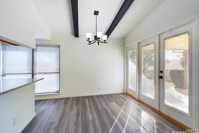 unfurnished dining area with french doors, a notable chandelier, lofted ceiling with beams, and dark hardwood / wood-style floors