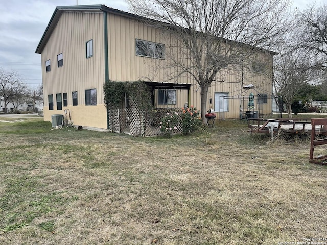 view of side of property featuring a yard and central air condition unit