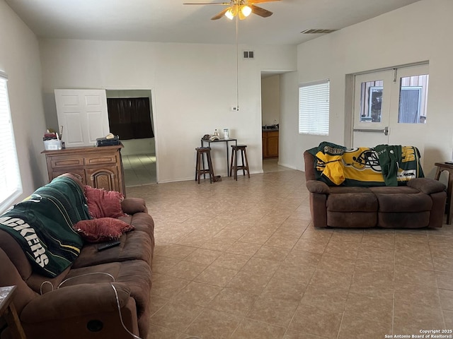 living room featuring ceiling fan and a wealth of natural light