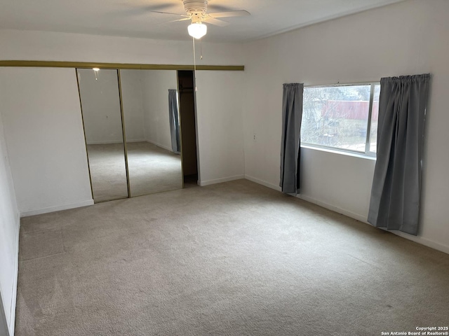 unfurnished bedroom with light colored carpet, ceiling fan, and a closet