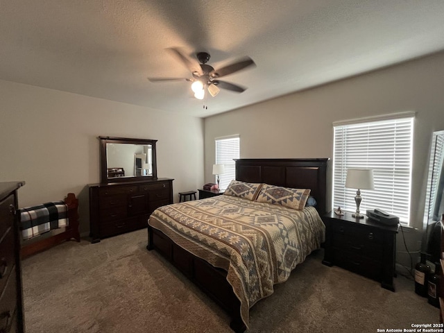 carpeted bedroom featuring ceiling fan and a textured ceiling