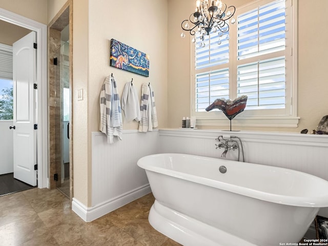 bathroom featuring a chandelier, a healthy amount of sunlight, and independent shower and bath