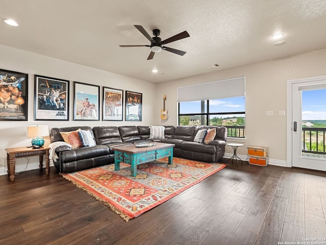 living room with dark hardwood / wood-style flooring, ceiling fan, and a wealth of natural light