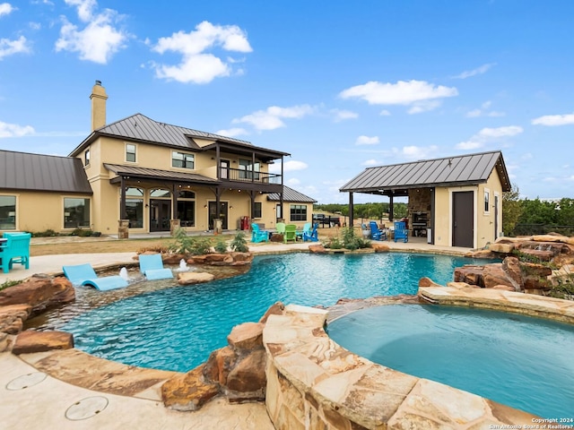 view of swimming pool featuring an outbuilding, an in ground hot tub, and a patio area