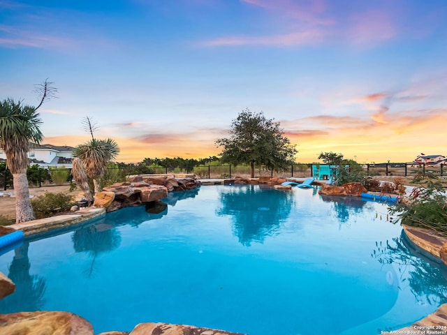 view of pool at dusk