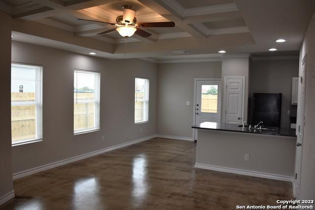 unfurnished living room with coffered ceiling, ornamental molding, ceiling fan, beamed ceiling, and sink