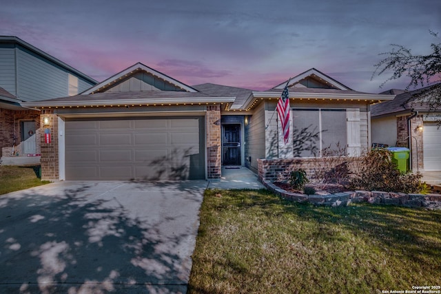 single story home featuring a garage and a lawn