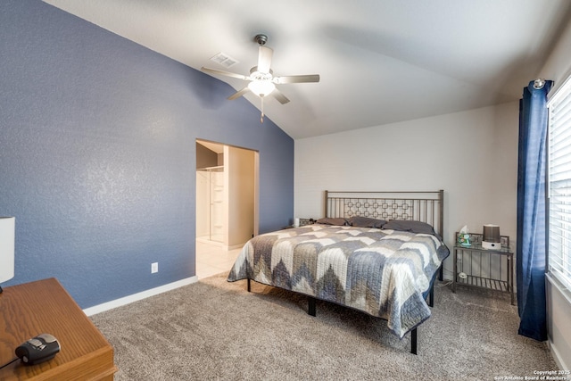 bedroom with ceiling fan, light colored carpet, connected bathroom, and vaulted ceiling