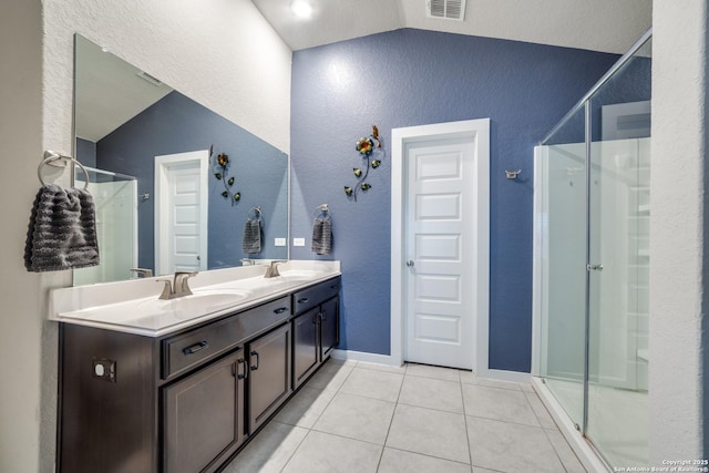 bathroom featuring vanity, a shower with door, tile patterned flooring, and vaulted ceiling