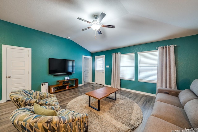 living room featuring ceiling fan, vaulted ceiling, and wood-type flooring