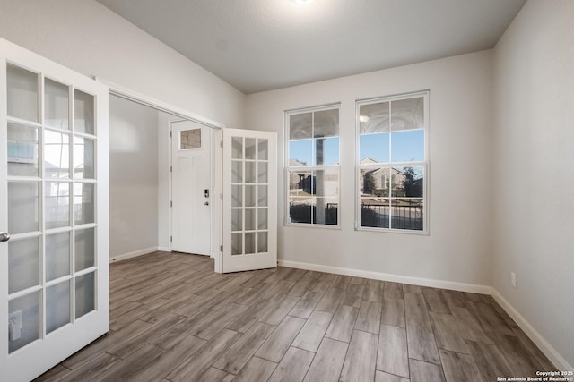 unfurnished room featuring french doors and wood-type flooring