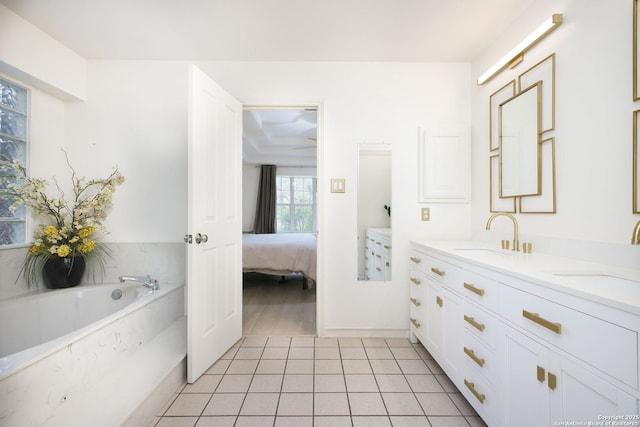 bathroom featuring tile patterned flooring, tiled bath, and vanity