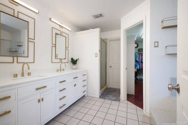 bathroom featuring tile patterned flooring, a shower with shower door, and vanity