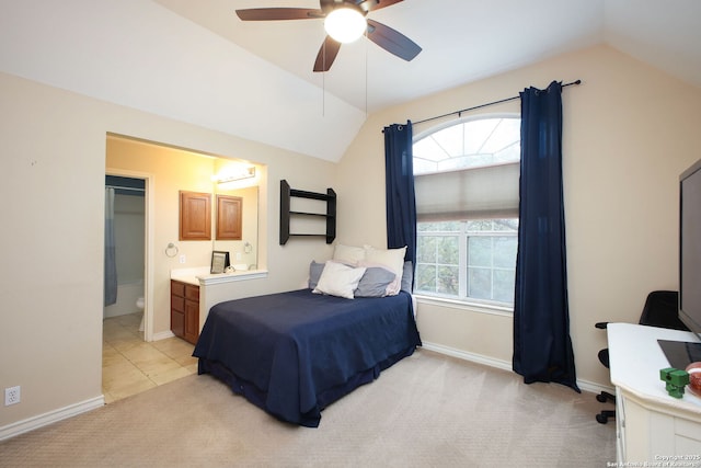 bedroom with ceiling fan, connected bathroom, vaulted ceiling, and light carpet