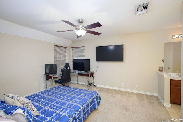 carpeted bedroom with vaulted ceiling, ensuite bath, and ceiling fan