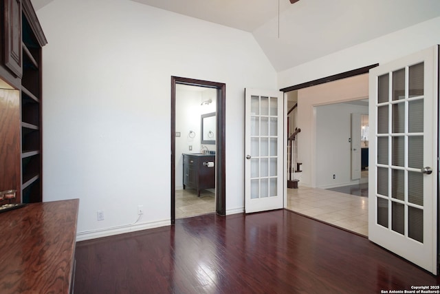 unfurnished room featuring sink, french doors, vaulted ceiling, and dark wood-type flooring