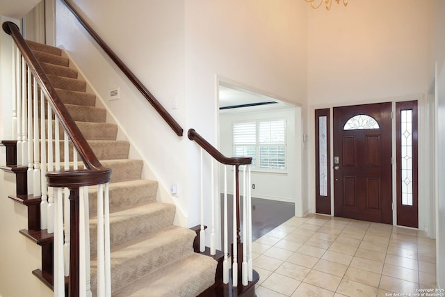 foyer entrance featuring a towering ceiling and light tile patterned flooring