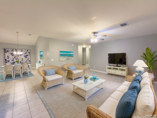 tiled living room with ceiling fan with notable chandelier