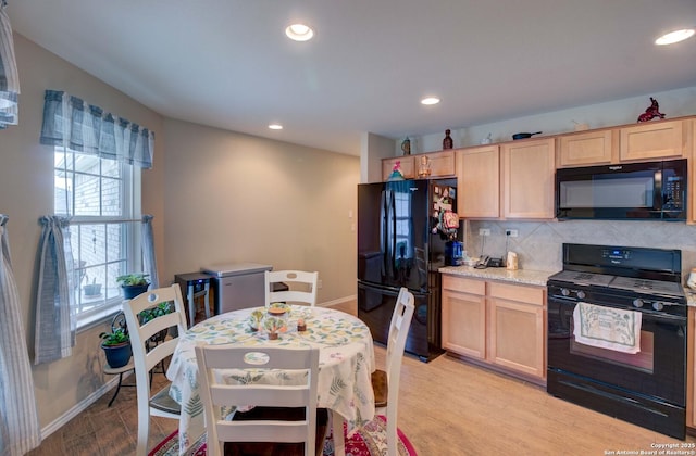 kitchen featuring light brown cabinets, black appliances, and light hardwood / wood-style floors