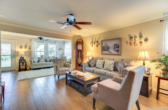 living room featuring ornamental molding, ceiling fan, and light hardwood / wood-style flooring