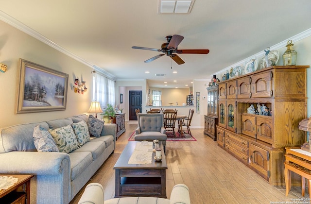 living room featuring ceiling fan, ornamental molding, and light hardwood / wood-style floors