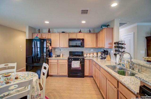 kitchen with black appliances, light stone countertops, light brown cabinetry, sink, and light hardwood / wood-style flooring