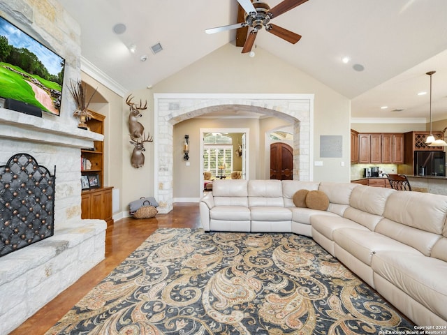 living room with ceiling fan, ornamental molding, lofted ceiling with beams, and built in features