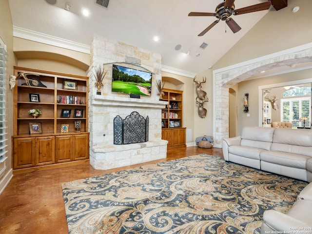 living room featuring built in shelves, high vaulted ceiling, ornamental molding, ceiling fan, and a stone fireplace