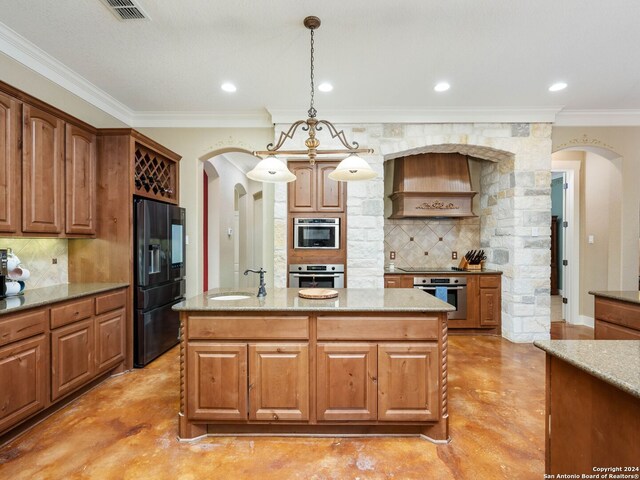 kitchen with an island with sink, premium range hood, oven, decorative light fixtures, and refrigerator with ice dispenser