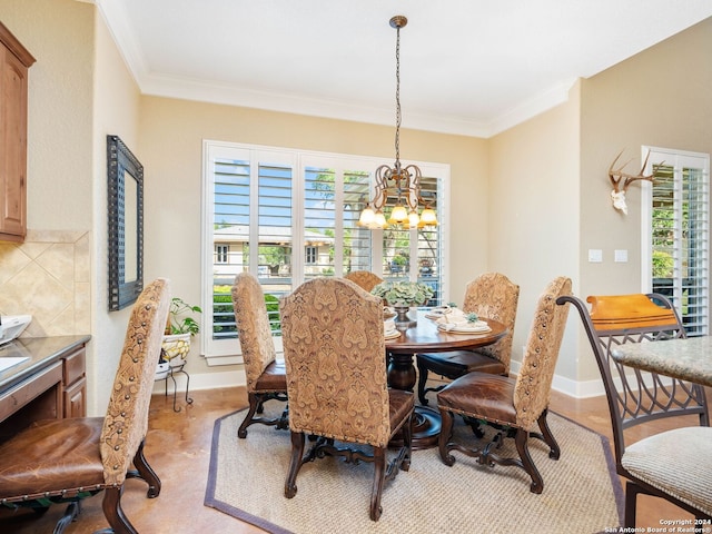 dining room with crown molding and a chandelier