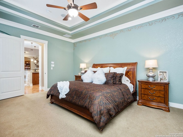 bedroom featuring ceiling fan, crown molding, light carpet, and a tray ceiling